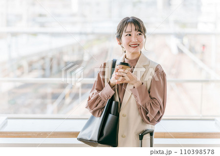 駅・公共施設でコーヒーを飲みながらデートの待ち合わせするビジネスウーマン 駅・公共施設でコーヒーを飲みながらデートの待ち合わせするビジネスウーマン 110398578