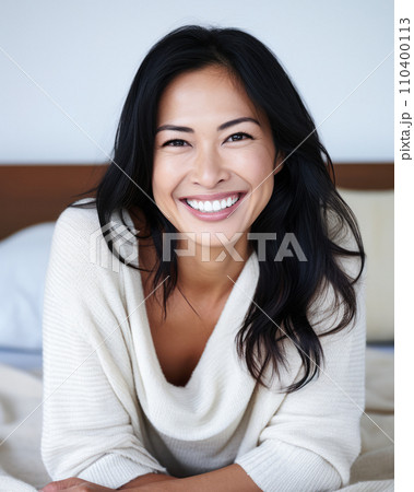 Smiling Asian woman at her home with a positive mood Smiling Asian woman at her home with a positive mood 110400113