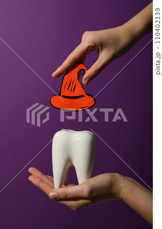 Big tooth with Halloween accessories, on a colored background. 110402139