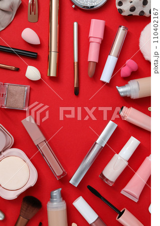 Decorative cosmetics on red background, top view Decorative cosmetics on red background, top view 110402167