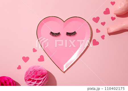 Flat lay plate in the shape of a heart on a pink background. 110402175