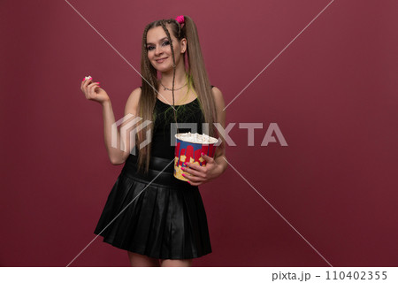 Portrait of impressed lady hand hold popcorn isolated on red color background Portrait of impressed lady hand hold popcorn isolated on red color background 110402355