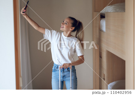 Cute trendy young girl with a suitcase Cute trendy young girl with a suitcase 110402956