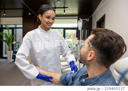 Doctor cosmetologist preparing male client arm for insertion of drip. 110403117