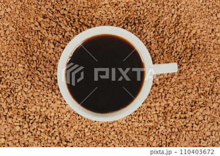 A cup of hot instant coffee on a background of freeze-dried granules A cup of hot instant coffee on a background of freeze-dried granules 110403672