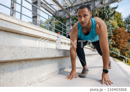 Young well-built man having a workout and looking determined Young well-built man having a workout and looking determined 110403808