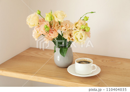 Coffee and a vase with flowers on the table 110404035