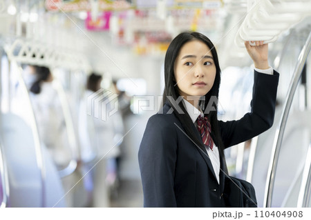 電車通学をする女子高校生 110404908