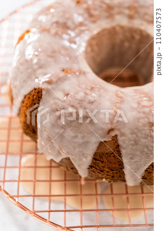 Glazing vanilla bundt cake with a white vanilla glaze. 110407573