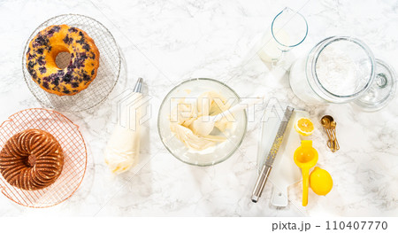 Flat lay. Skillfully combine ingredients using a hand mixer to prepare a rich, smooth cream cheese buttercream frosting, which is perfect for adorning the bundt cake. Flat lay. Skillfully combine ingredients using a hand mixer to prepare a rich, smooth cream cheese buttercream frosting, which is perfect for adorning the bundt cake. 110407770