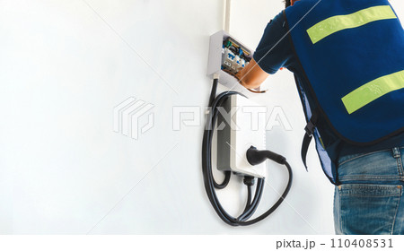 Certified male Electrician Installing Home EV Charger 110408531
