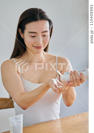 ハンドクリームを手につける30代女性 110408993