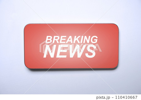 Closeup view of the mobile phone screen with breaking news inscription Closeup view of the mobile phone screen with breaking news inscription 110410667