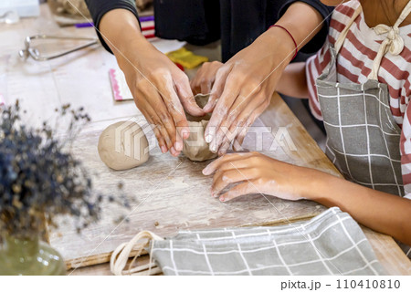 Kids making a craft of a porcelain mug from wet clay Kids making a craft of a porcelain mug from wet clay 110410810
