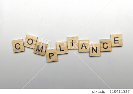 A row of wooden cubes with compliance letters A row of wooden cubes with compliance letters 110411527