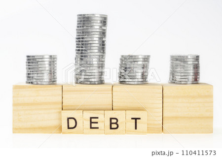 Stack of silver coin with wooden cube with debt words 110411573