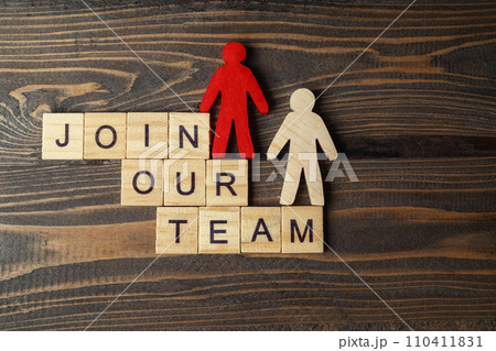 Wooden figures and wooden cubes with Join Our Team letters on a wooden table 110411831