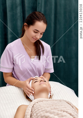 Beautiful woman getting face massage treatment in beauty salon. girl enjoys this procedure. 110413038