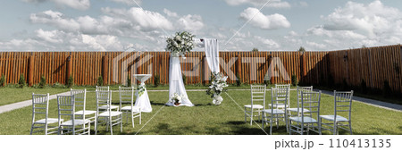 Outdoor wedding venue with chairs and arch Outdoor wedding venue with chairs and arch 110413135