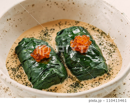 Stuffed green cabbage rolls with sauce in restaurant-style plating, served red caviar Stuffed green cabbage rolls with sauce in restaurant-style plating, served red caviar 110413461