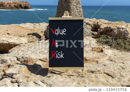 VAR Value at risk symbol. Concept words VAR Value at risk on beautiful black chalk blackboard. Beautiful stone beach blue sea background. Business and VAR Value at risk concept. Copy space. 110415758