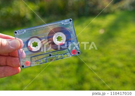 Old audio cassette on green grass background Old audio cassette on green grass background 110417010