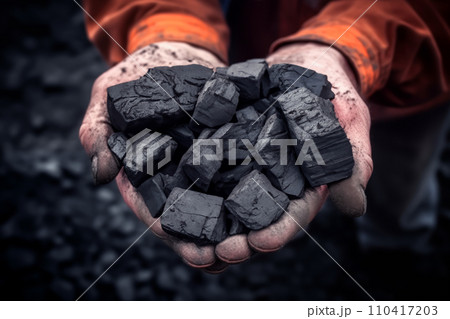 Coal mining in mine. Coal in hands of miner worker. Metallurgical coal for steel.  110417203