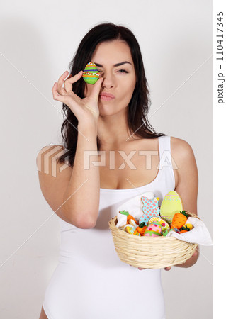 Beautiful woman with a basket of Easter desserts 110417345