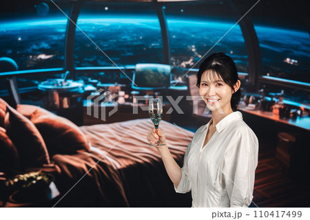 宇宙のホテルでスパークリングワインを楽しむ女性 宇宙のホテルでスパークリングワインを楽しむ女性 110417499