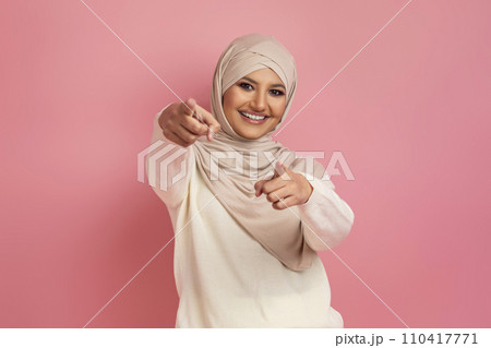 Arab woman in a hijab pointing with both hands at the camera 110417771