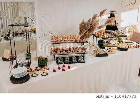 Assortment of delicious snacks on the open buffet festive table in restaurant. Catering plate 110417773