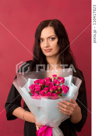 Beautiful woman with a bouquet of small pink roses Beautiful woman with a bouquet of small pink roses 110417823