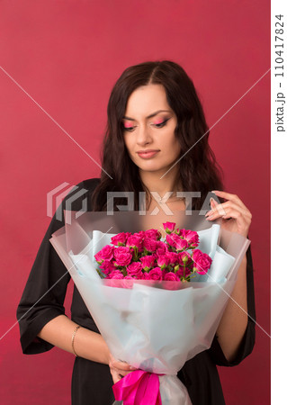 Beautiful woman with a bouquet of small pink roses Beautiful woman with a bouquet of small pink roses 110417824