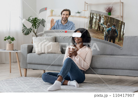 VR glasses transport young african american woman into the world of virtual video calls VR glasses transport young african american woman into the world of virtual video calls 110417907