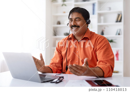 Mature indian businessman have video call, working from home office Mature indian businessman have video call, working from home office 110418013