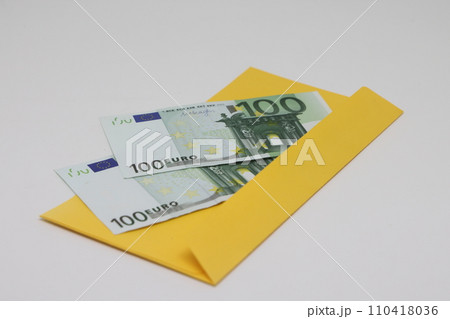 Banknotes in a yellow envelope on a black background. Bribery concept. Salary in envelopes. Financial fraud. Close up 110418036