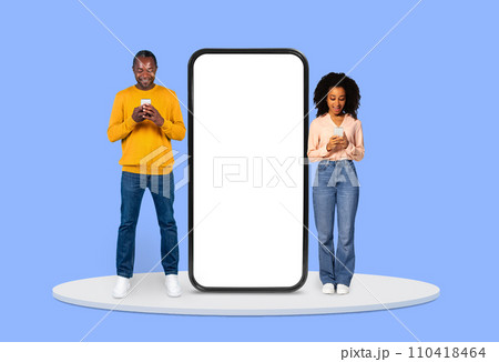 Man and woman focused on their smartphones beside huge blank display Man and woman focused on their smartphones beside huge blank display 110418464