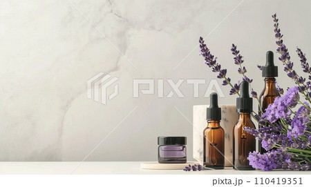 Beauty product display, slender flacons and oils, arranged with fresh lavender, on a monochrome ivory surface Beauty product display, slender flacons and oils, arranged with fresh lavender, on a monochrome ivory surface 110419351