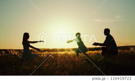 Silhouettes of parents playing and hugging daughter running from dad to mommy Silhouettes of parents playing and hugging daughter running from dad to mommy 110419722
