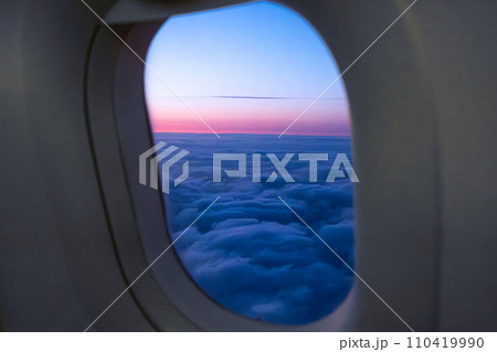 Amazing view of clouds and sunset in window on an airplane.  110419990
