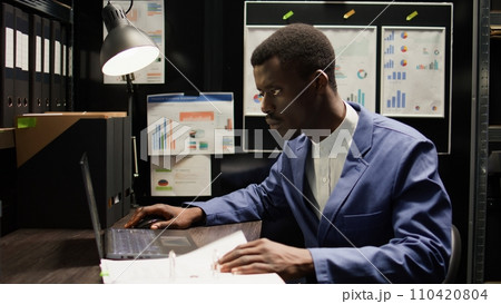 Detective inspector works in office, analyzing forensic evidence and conducts detailed background checks. Police officer identifying illegal activity, and gathering crucial information. Zoom-in shot. Detective inspector works in office, analyzing forensic evidence and conducts detailed background checks. Police officer identifying illegal activity, and gathering crucial information. Zoom-in shot. 110420804