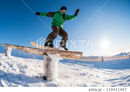 Snowboarder sliding on a rail Snowboarder sliding on a rail 110421467