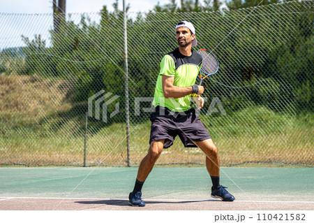 Tennis player hitting backhand at ball 110421582