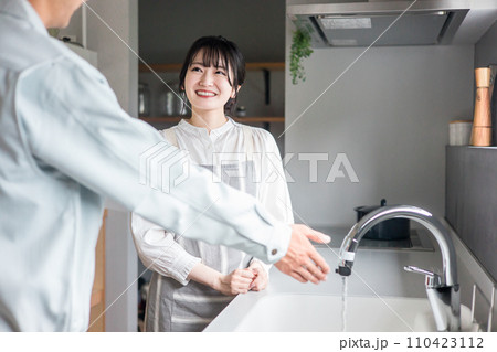 キッチンで水道屋・設備屋の説明を受ける主婦の女性 110423112