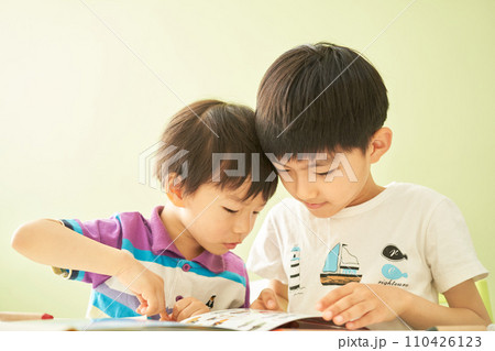 一緒に図鑑を見る2人の男の子 110426123