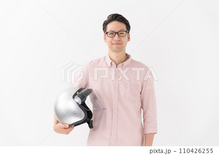 バイクヘルメットを抱える男性 110426255