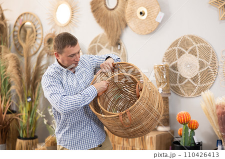 Man looking for functional spacious wicker baskets at store Man looking for functional spacious wicker baskets at store 110426413