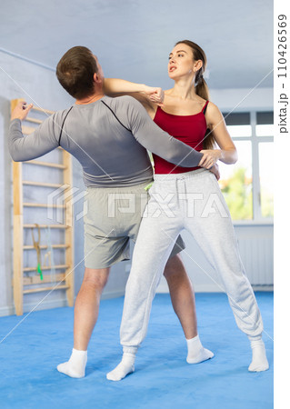 Young girl practicing self-defense techniques in pair with middle-aged man 110426569