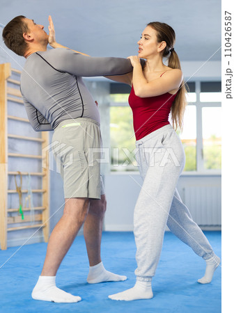 Adult man and young woman training self-defense techniques 110426587