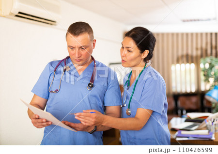 Two doctors checking patient papers in clinic 110426599